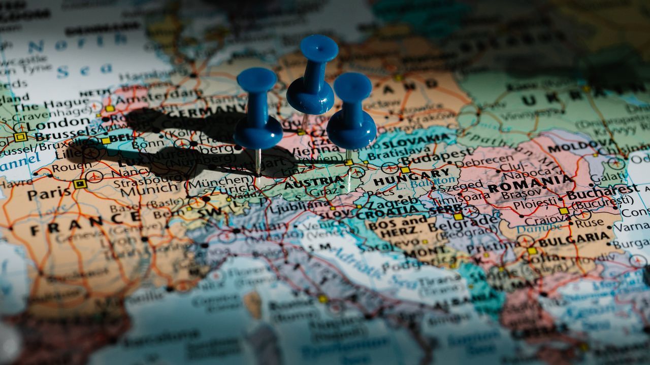 Detailed close-up of a European map with blue pushpins marking important locations.