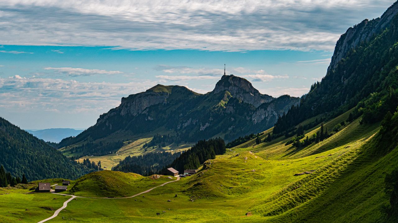 Breathtaking view of lush green valleys and mountains in Sennwald, Switzerland.